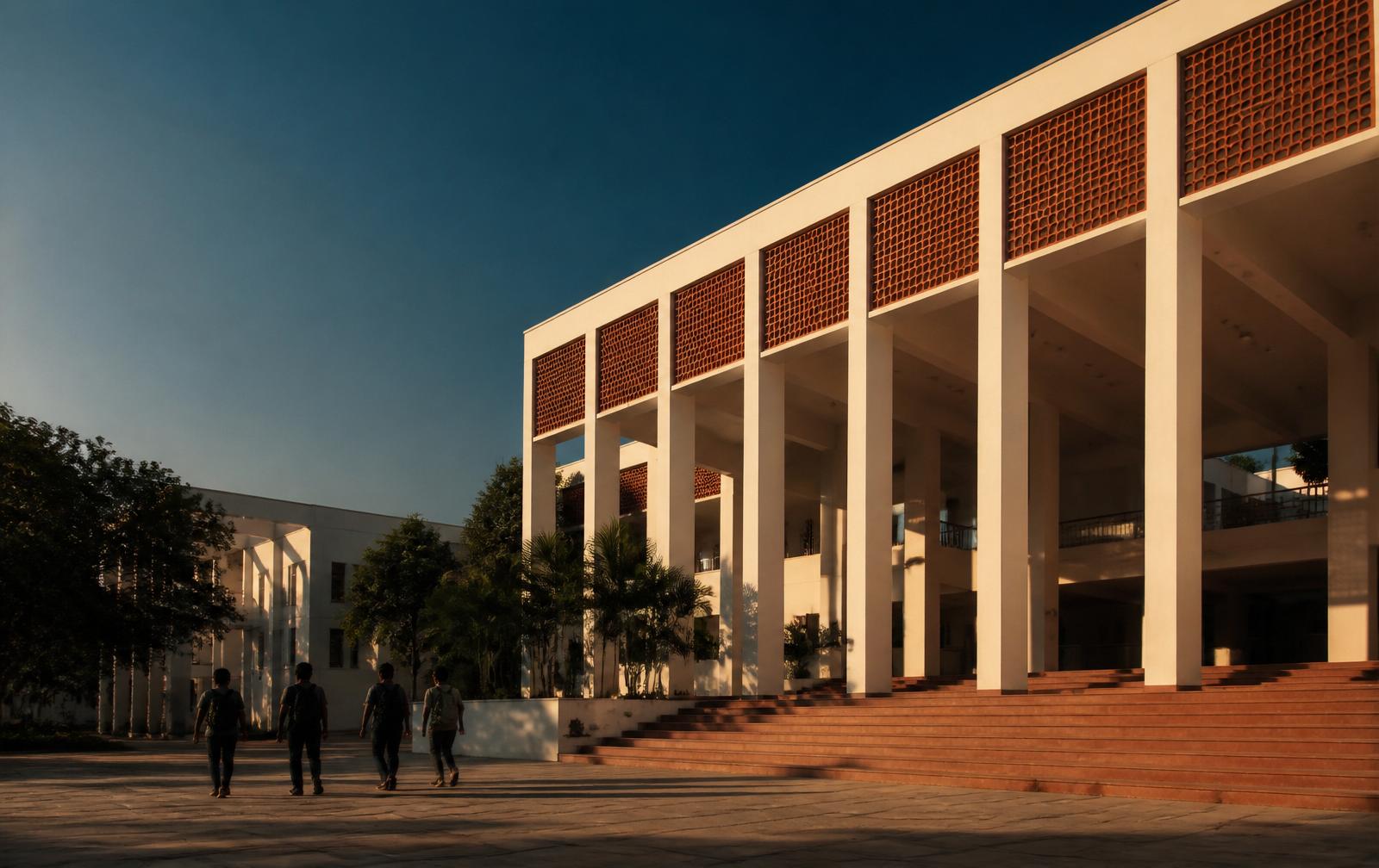 A modern South Indian engineering college building at golden hour with students walking through the courtyard